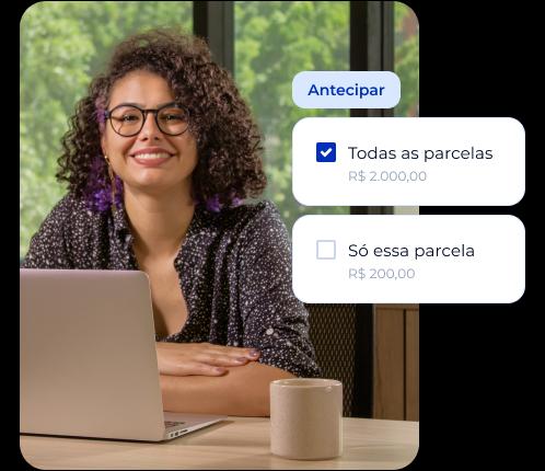 Mulher morena de cabelos cacheados e óculos trabalhando em seu notebook. Ao seu lado, informações sobre a antecipação de uma cobrança parcelada onde é possível receber o valor antecipado de todas as parcelas ou somente de uma delas.